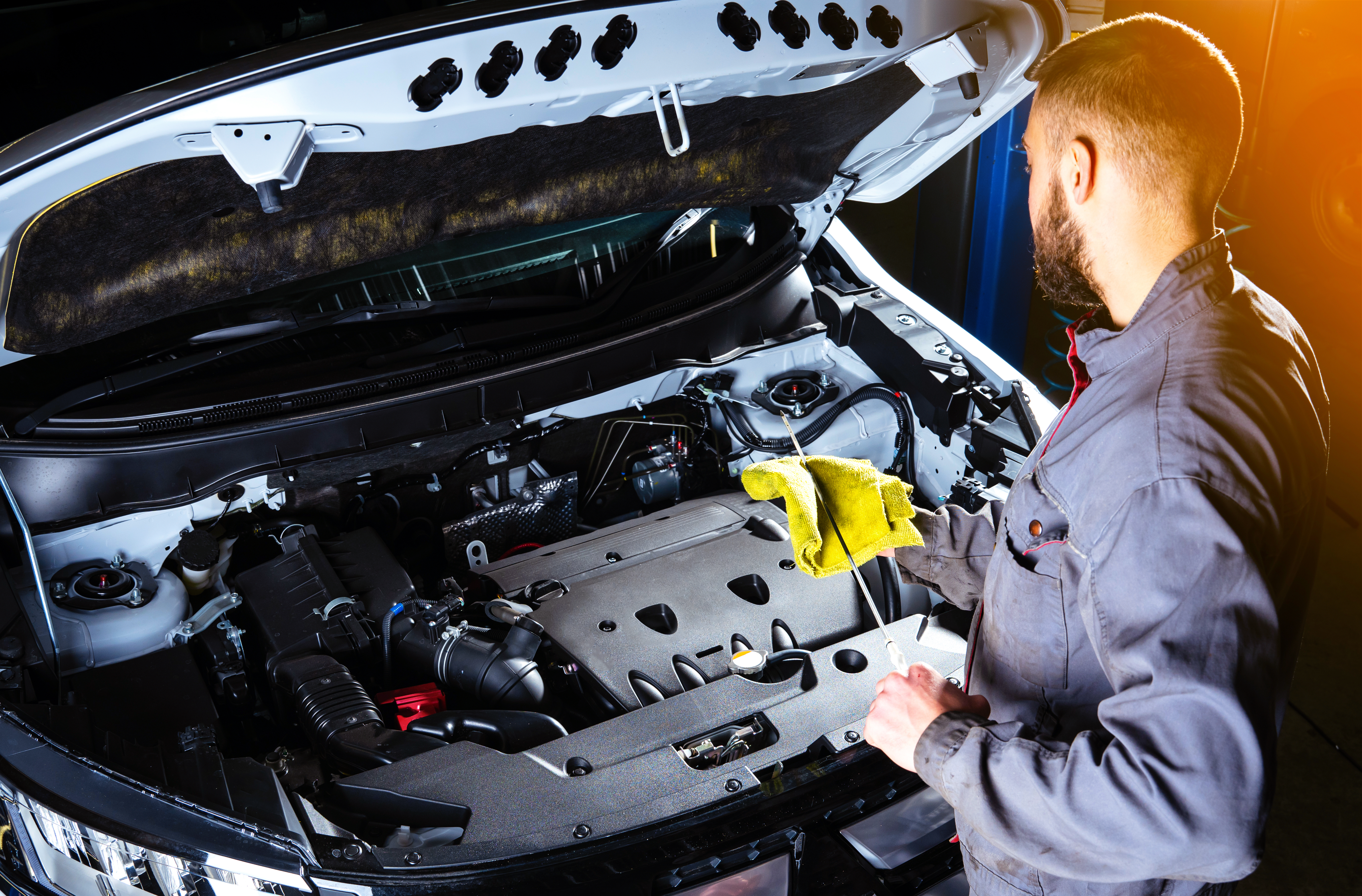 Photo of person working on a car with the hood up