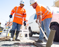 Photo of two Caltrans maintenance workers replacing a concrete slab