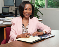 A photo of Caltrans Inspector General Rhonda Craft sitting at her desk