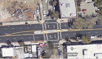 Image of an intersection barrier used to limit left-turn movement through an intersection with a raised island forcing drivers to reduce approach speed